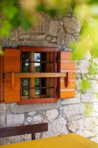 een raam aan de zijkant van een stenen gebouw bij Villa Millefoglie, a century-old stone house nestled in a nature park in Lupoglav