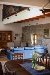 een woonkamer met een tafel en een blauwe bank bij Villa Millefoglie, a century-old stone house nestled in a nature park in Lupoglav