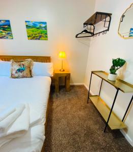 a bedroom with a bed and a table with a lamp at Westwood Drive in Treharris +29 photos