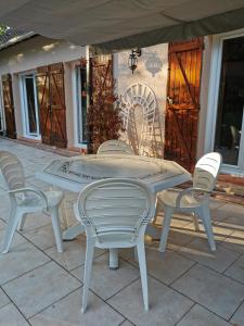 einen weißen Tisch und Stühle auf einer Terrasse in der Unterkunft Chambres à la campagne chez l'habitant in Boissy-sans-Avoir