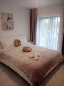 1 dormitorio con 1 cama con 2 toallas en Izabella Guest House, en Săcele