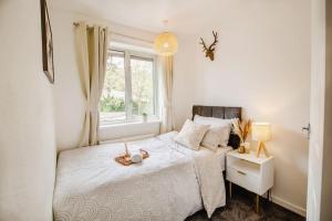 Serene Boho Retreat: White Oak Charm House 7ppl في شيفيلد: غرفة نوم بسريرين ونافذة