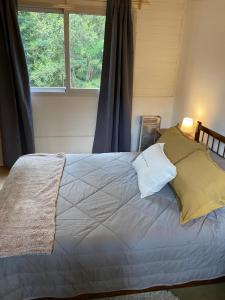 a bedroom with a large bed with a window at La Amapola in Villa La Angostura