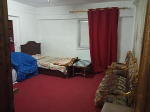 a bedroom with a bed and a red curtain at Flower Roomsللرجال فقط in Alexandria