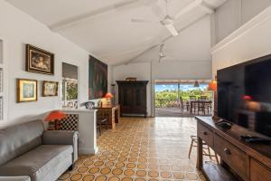 a living room with a couch and a flat screen tv at Villa Papaya in Willemstad