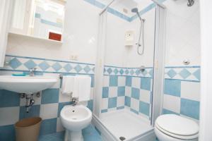baño azul y blanco con aseo y lavamanos en Hotel Baia Verde, en Maiori