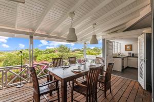 a dining room with a table and chairs on a deck at Villa Papaya in Willemstad