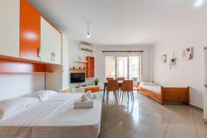 una camera da letto con un letto grande e una sala da pranzo di Orange Beachfront Studio by PS a Golem Altre 22 foto