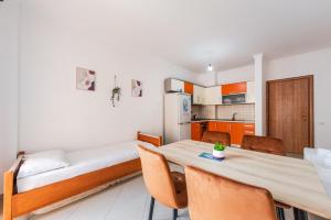 una stanza con un tavolo, un letto e una cucina di Orange Beachfront Studio by PS a Golem