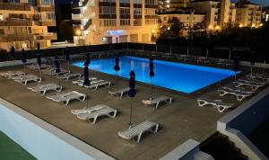an overhead view of a swimming pool with chaise lounge chairs and a row at Nautilus Hotel in Roses