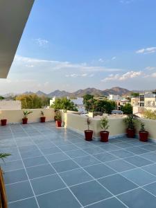 a balcony with a blue tile floor and potted plants at Karni Nivvas - Luxury Redefined in Udaipur