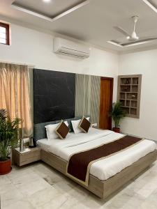 a bedroom with a large bed with a black headboard at Karni Nivvas - Luxury Redefined in Udaipur