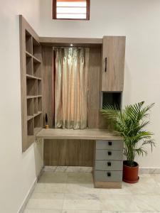 Zimmer mit einem Schreibtisch, einem Fenster und einer Pflanze in der Unterkunft Karni Nivvas - Luxury Redefined in Udaipur