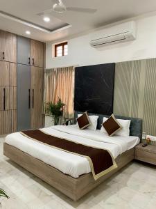 Schlafzimmer mit einem großen Bett mit einem schwarzen Kopfteil in der Unterkunft Karni Nivvas - Luxury Redefined in Udaipur