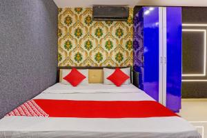 a bedroom with a bed with red pillows at Lotus Hotel in Surat