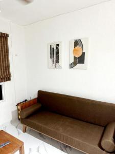 - un canapé dans le salon avec des photos sur le mur dans l'établissement Departamento en tulum Quintana roo, à Tulum