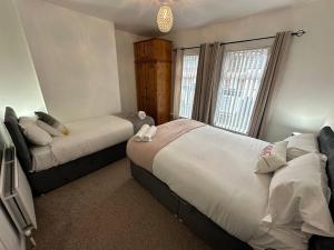 1 dormitorio con 2 camas y ventana en 2br Stylish Ormeau Road House en Belfast
