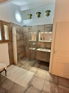 La salle de bains est pourvue d'une douche en verre et d'un lavabo. dans l'établissement I Carbonni - Bergerie 80m2 entre mer et montagne, à Sotta