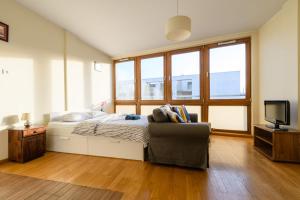 a bedroom with a bed and a couch and a tv at Luxury apartment Piękna in Warsaw