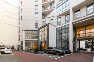 een groot gebouw met auto's geparkeerd voor het bij Luxury apartment Piękna in Warschau