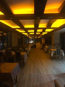 Kolağası otel في جوروم: غرفة طعام بها طاولات وكراسي واضاءات صفراء