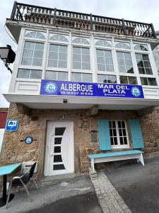 budynek z niebieskim znakiem na górze w obiekcie Albergue Mar del Plata w mieście Fisterra