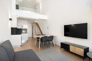 een woonkamer met een bank, een tv en een tafel bij apartamentos reformados con garajes incluido in San Sebastián de los Reyes