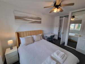 a bedroom with a bed and a ceiling fan at FamilyFriendly- Sleep5- FreeParking- PrivateGarden in Rochester +21 photos