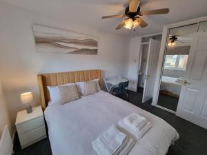 a bedroom with a bed and a ceiling fan at Captivating 3-Bed House in Strood Rochester Kent in Rochester