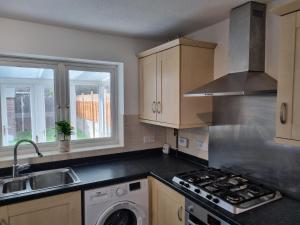 a kitchen with a sink and a stove top oven at Captivating 3-Bed House in Strood Rochester Kent in Rochester