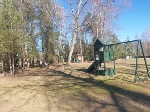 a park with a swing set in the grass at Poilsio namelis in Kaišiadorys