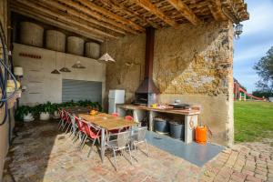an outdoor kitchen with a wooden table and chairs at Can Guinau in Aiguaviva