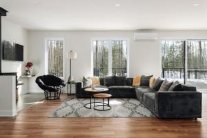 a living room with a couch and a table at Sezona - Nature escape in Tremblant in Saint-Rémi-dʼAmherst +49 photos
