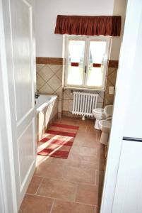 een badkamer met een bad, 2 toiletten en een raam bij 5 bedrooms villa with private pool sauna and enclosed garden at Poggio Catino in Poggio Catino