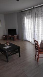 sala de estar con mesa, sofá y TV en Apartment Lavinia, en Zadar
