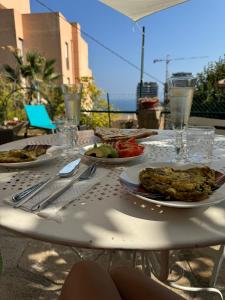 una mesa blanca con platos de comida. en Maison avec jardin, vue mer aux portes de Monaco, en Beausoleil