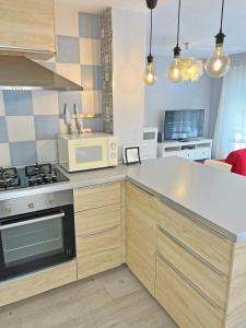 a kitchen with a stove and a microwave at Estación Tren Reformado 2 habitaciones in Alicante
