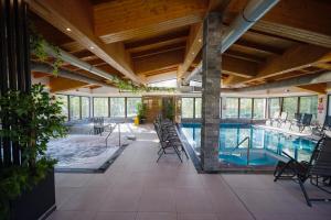 a large indoor pool with chairs and a swimming pool at Hotel Yara in Vişeu de Sus