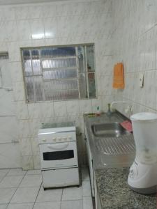 a small kitchen with a sink and a stove at Casa Central em Petrolina in Petrolina