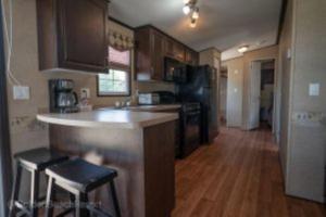 a kitchen with a counter and some chairs in it at 2 Bedroom Harbor Front Cottage 2 in Roseneath