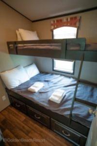 een slaapkamer met een stapelbed en 2 handdoeken bij 2 Bedroom Harbor Front Cottage 3 in Roseneath