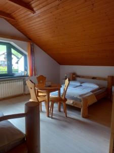 1 dormitorio con 1 cama, mesa y sillas en Na Brzegu, en Szczyrk