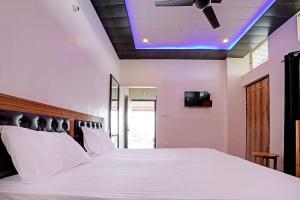 Super OYO Sadhna Holiday Home tesisinde bir odada yatak veya yataklar