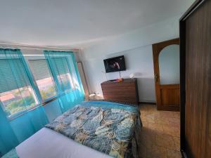 a bedroom with a bed and a dresser and two windows at Apartament cu 2 dormitoare ,ultracentral in Arad