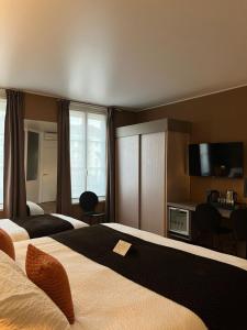 a hotel room with two beds and a flat screen tv at HOTEL & SPA Le Renard Centre in Châlons-en-Champagne