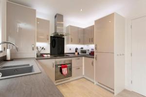 a kitchen with a sink and a stove top oven at DBS Serviced Apartments - The Mews in Castle Donington