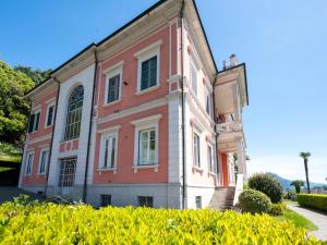 an old red and white building with bushes in front at Apartment Gardenia by Interhome in Verbania