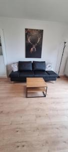 a living room with a blue couch and a coffee table at Hahnenkleer Tied 2 in Goslar