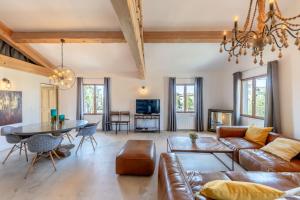 a living room with a couch and a table at Olive- Vaste appartement donnant sur la Sorgue in LʼIsle-sur-la-Sorgue