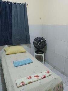 a bed in a room with a chair and a table at Casa Central em Petrolina in Petrolina